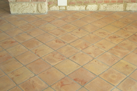 Tavella in cotto rosata con venature rosse.