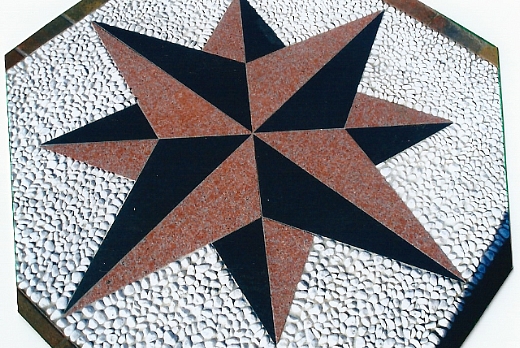 Rosa dei venti in marmo in due colori: nero e rosso Verona, con sfondo in ciotolini bianchi