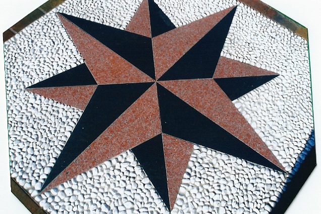 Rosa dei venti in marmo in due colori: nero e rosso Verona, con sfondo in ciotolini bianchi