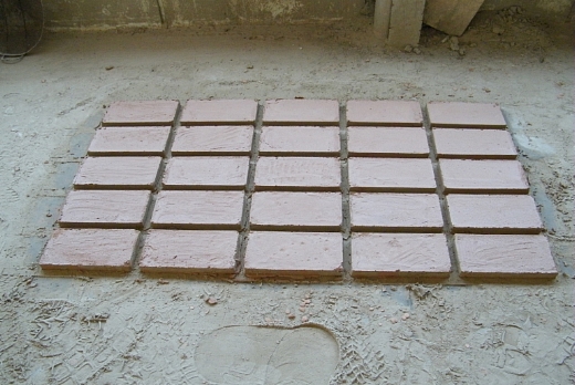 una fase della lavorazione del manufatto che rimane ad essiccarsi sul pavimento riscaldato