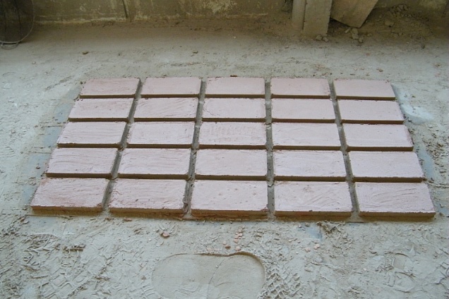 una fase della lavorazione del manufatto che rimane ad essiccarsi sul pavimento riscaldato