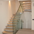 Scala a giorno autoportante con gradino in legno e balaustra in vetro autoportante